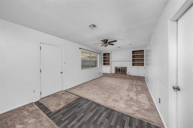 7506 NW Welco Ave, Lawton, OK 73505 - unfurnished living room featuring a ceiling fan, a textured ceiling, dark wood-style floors, baseboards, and built in shelves