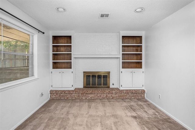 7506 NW Welco Ave, Lawton, OK 73505 - unfurnished living room featuring carpet, a fireplace, a textured ceiling, and baseboards