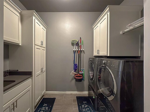 15321 Salem Creek Pl, Edmond, OK 73013 - washroom with cabinet space, washing machine and dryer, baseboards, and wood finished floors