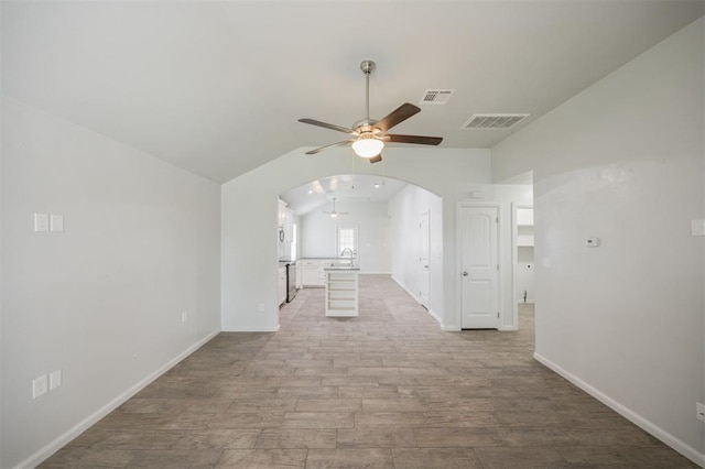 6100 SE 7th St, Midwest City, OK 73110 - spare room with ceiling fan, lofted ceiling, arched walkways, wood finished floors, and a sink
