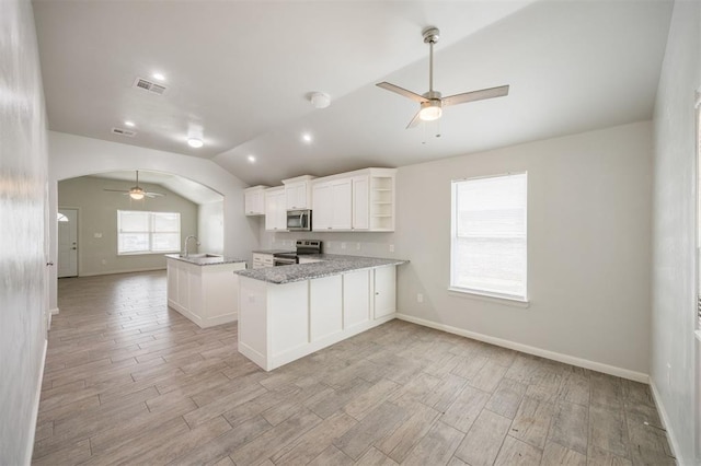 6100 SE 7th St, Midwest City, OK 73110 - kitchen featuring appliances with stainless steel finishes, a ceiling fan, vaulted ceiling, open shelves, and arched walkways