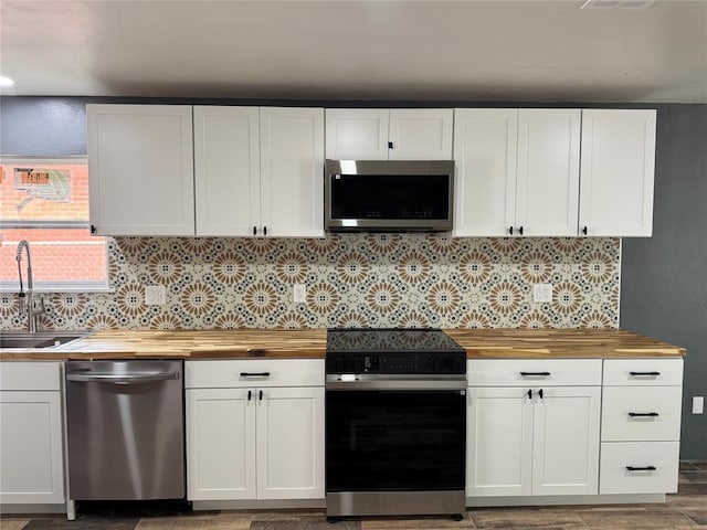 106 Briarwood Crossroads, Moore, OK 73160 - kitchen featuring stainless steel appliances, wooden counters, a sink, white cabinetry, and decorative backsplash
