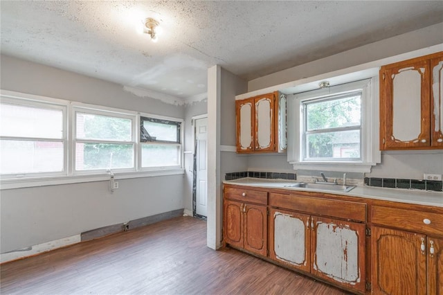 2325 E Madison St, Oklahoma City, OK 73111 - kitchen featuring wood finished floors, brown cabinets, light countertops, and a textured ceiling