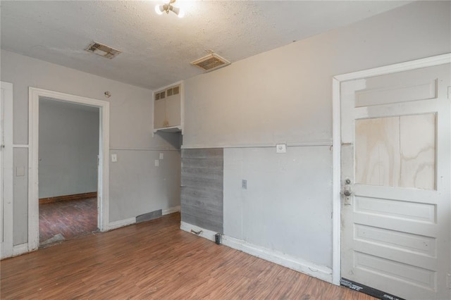 2325 E Madison St, Oklahoma City, OK 73111 - spare room with wood finished floors and a textured ceiling