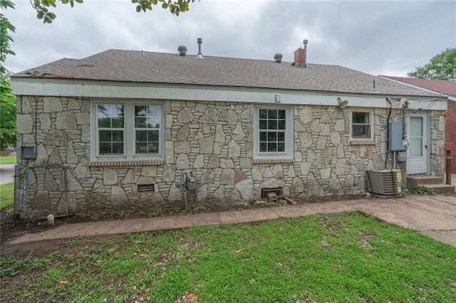 2325 E Madison St, Oklahoma City, OK 73111 - view of side of property featuring stone siding, a lawn, and a shingled roof