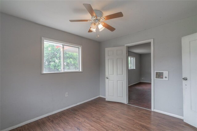 2325 E Madison St, Oklahoma City, OK 73111 - unfurnished bedroom featuring multiple windows, wood finished floors, and a ceiling fan