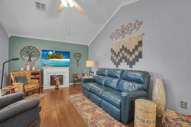 409 Pheasant Cir, Altus, OK 73521 - living room with lofted ceiling, ornamental molding, wood finished floors, ceiling fan, and a fireplace with raised hearth