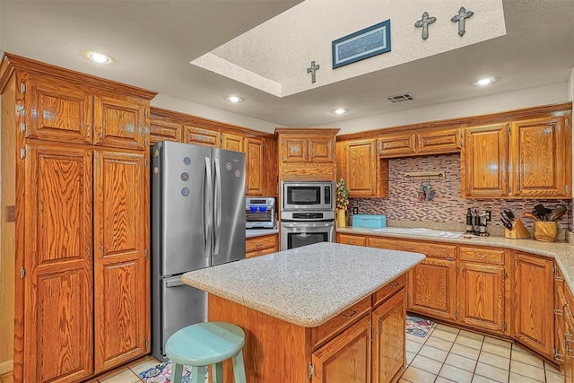 409 Pheasant Cir, Altus, OK 73521 - kitchen with stainless steel appliances, light tile patterned floors, brown cabinetry, tasteful backsplash, and recessed lighting