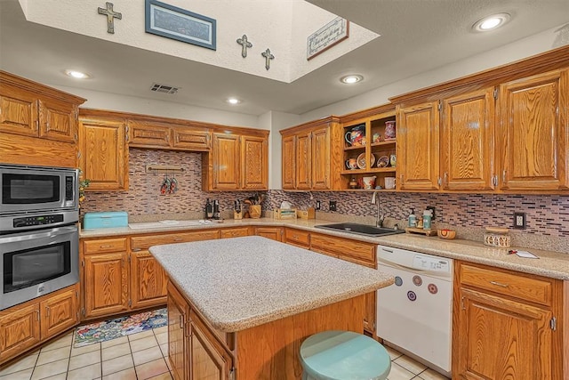 409 Pheasant Cir, Altus, OK 73521 - kitchen with appliances with stainless steel finishes, light tile patterned floors, backsplash, brown cabinets, and recessed lighting