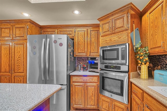 409 Pheasant Cir, Altus, OK 73521 - kitchen with stainless steel appliances, decorative backsplash, brown cabinets, and recessed lighting