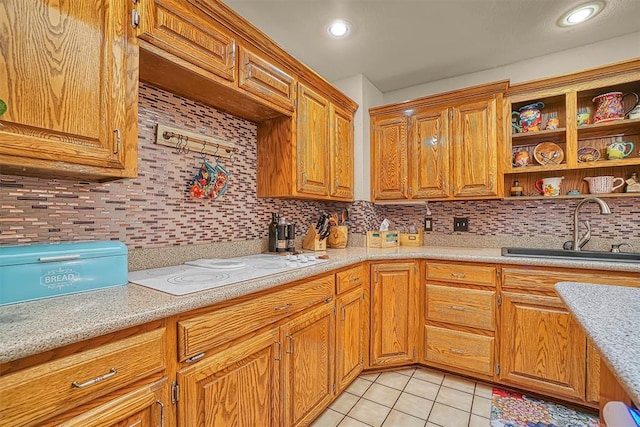 409 Pheasant Cir, Altus, OK 73521 - kitchen with white electric stovetop, light countertops, tasteful backsplash, light tile patterned flooring, and brown cabinets