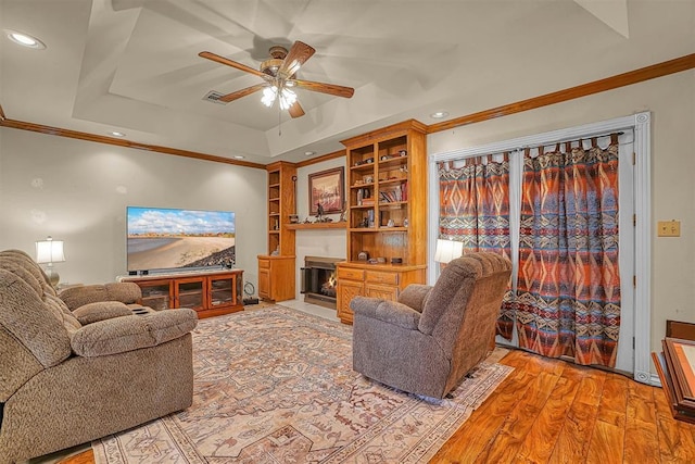 409 Pheasant Cir, Altus, OK 73521 - living area featuring a tray ceiling, ceiling fan, recessed lighting, a fireplace with flush hearth, and crown molding