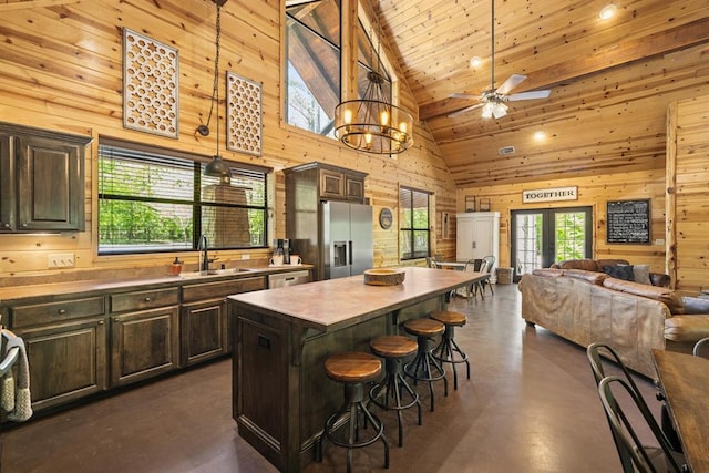 372 Timber Creek Trl, Broken Bow, OK 74728 - kitchen with stainless steel appliances, a sink, finished concrete floors, wood walls, and high vaulted ceiling