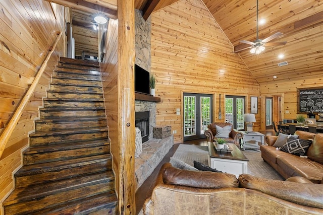 372 Timber Creek Trl, Broken Bow, OK 74728 - living room featuring wooden ceiling, wooden walls, stairs, high vaulted ceiling, and a stone fireplace