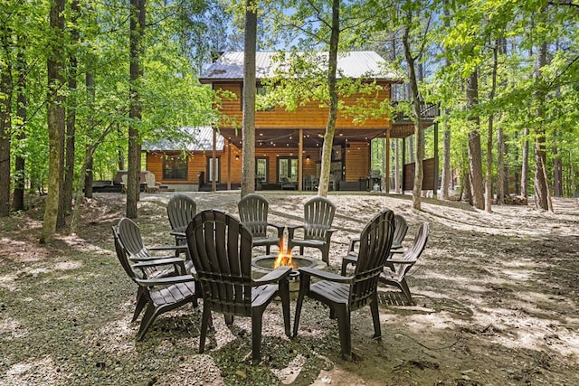 372 Timber Creek Trl, Broken Bow, OK 74728 - rear view of house with log veneer siding, an outdoor fire pit, a patio, and metal roof