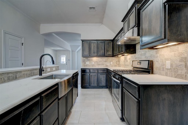 4116 NW 155th St, Edmond, OK 73013 - kitchen with stainless steel range with gas cooktop, under cabinet range hood, a sink, arched walkways, and light tile patterned flooring