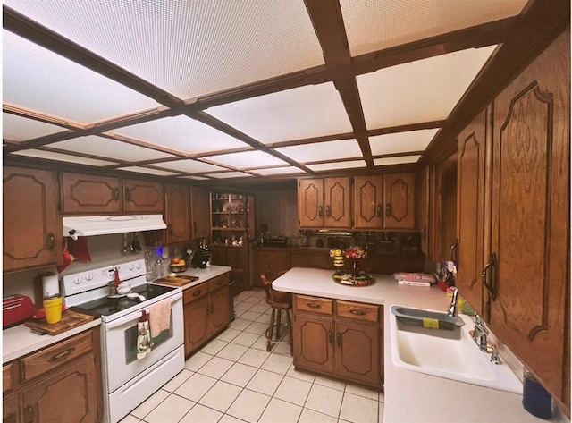 12301 US Highway 77, Lexington, OK 73051 - kitchen with white electric range oven, under cabinet range hood, light tile patterned floors, coffered ceiling, and light countertops