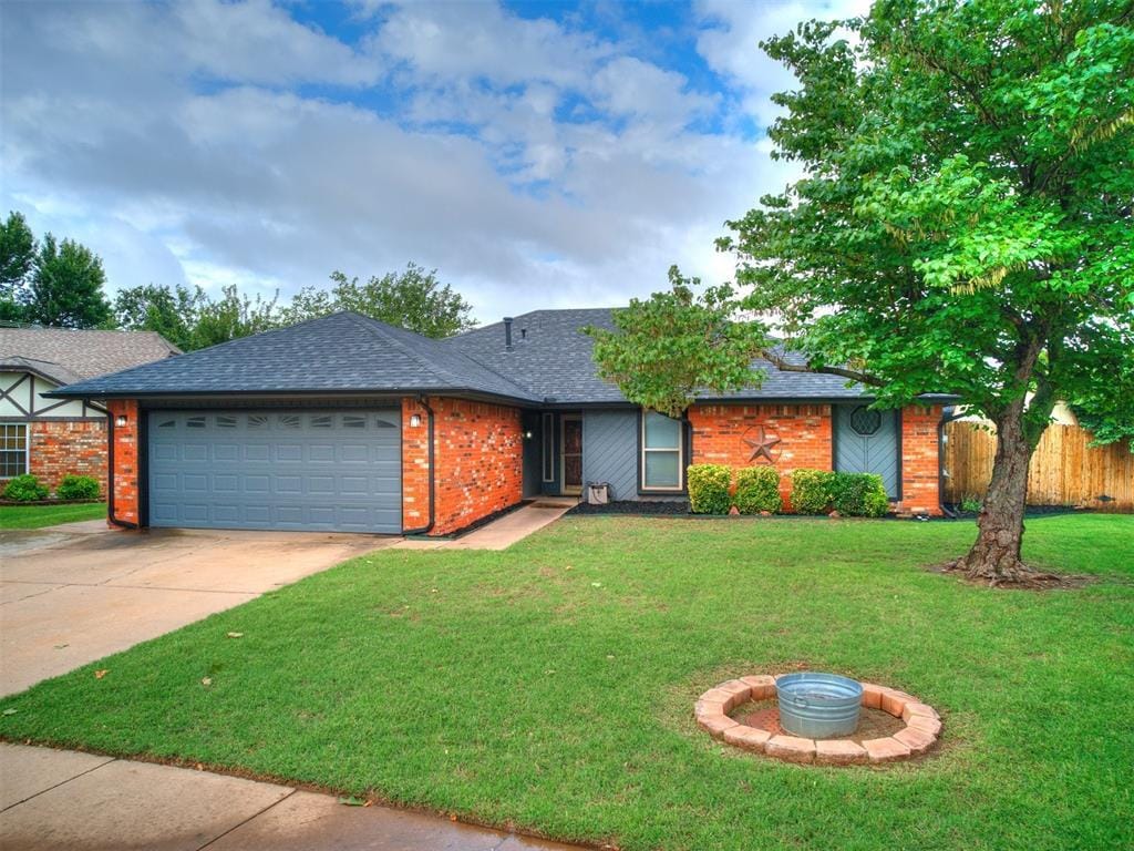 2916 Morrison Trl, Edmond, OK 73012 - view of front facade featuring an attached garage, driveway, roof with shingles, and brick siding