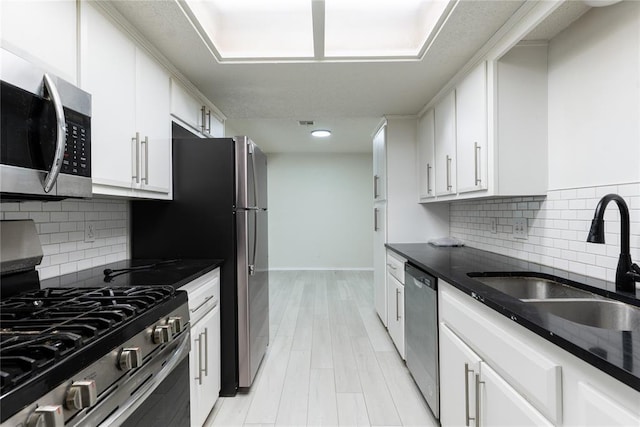 1422 SW 96th St, Oklahoma City, OK 73159 - kitchen with appliances with stainless steel finishes, a sink, white cabinetry, baseboards, and tasteful backsplash