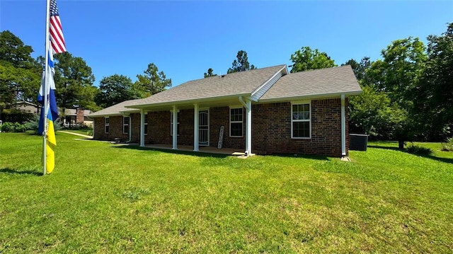 339770 E 1040th Cir, Meeker, OK 74855 - view of front facade featuring a front yard, brick siding, a patio area, and central AC unit