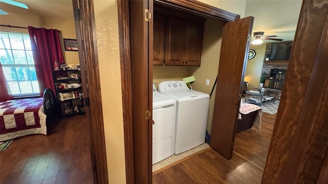 339770 E 1040th Cir, Meeker, OK 74855 - laundry area with ceiling fan, washing machine and dryer, wood finished floors, a brick fireplace, and cabinet space