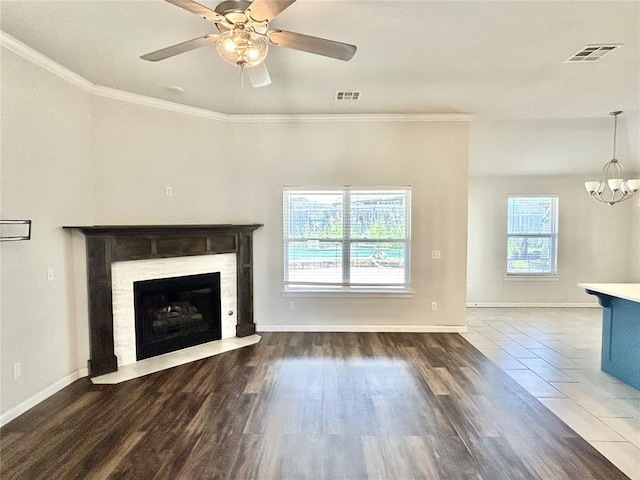 9632 Ashford Dr, Yukon, OK 73099 - unfurnished living room featuring a fireplace with flush hearth, a ceiling fan, a chandelier, ornamental molding, and wood finished floors