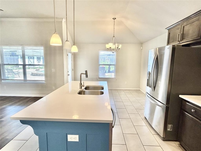9632 Ashford Dr, Yukon, OK 73099 - kitchen featuring stainless steel refrigerator with ice dispenser, light countertops, dark brown cabinets, light tile patterned floors, and vaulted ceiling