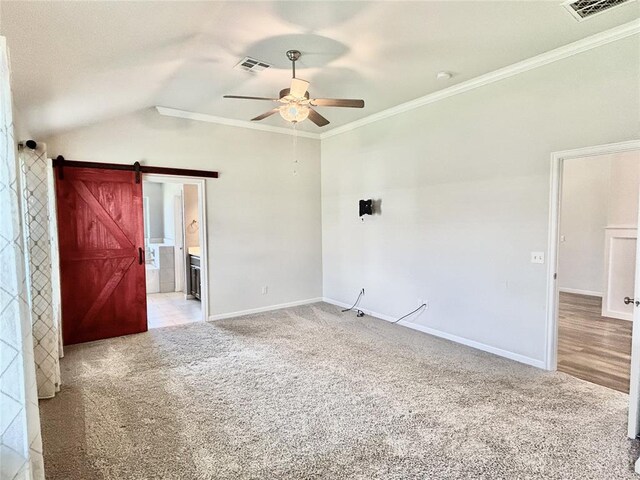 9632 Ashford Dr, Yukon, OK 73099 - carpeted empty room featuring a ceiling fan, vaulted ceiling, ornamental molding, and a barn door