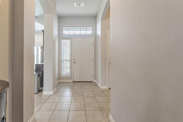 19005 Valencia Park Dr, Edmond, OK 73012 - foyer entrance featuring light tile patterned flooring, arched walkways, and baseboards