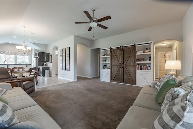 19005 Valencia Park Dr, Edmond, OK 73012 - living area with arched walkways, a ceiling fan, a chandelier, light colored carpet, and a barn door