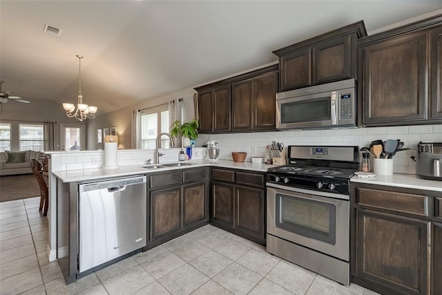 19005 Valencia Park Dr, Edmond, OK 73012 - kitchen with stainless steel appliances, a sink, open floor plan, tasteful backsplash, and light countertops