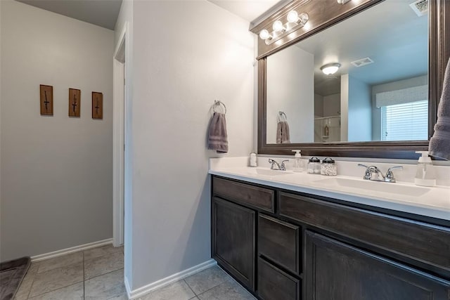 19005 Valencia Park Dr, Edmond, OK 73012 - bathroom featuring double vanity, baseboards, tile patterned floors, and a shower