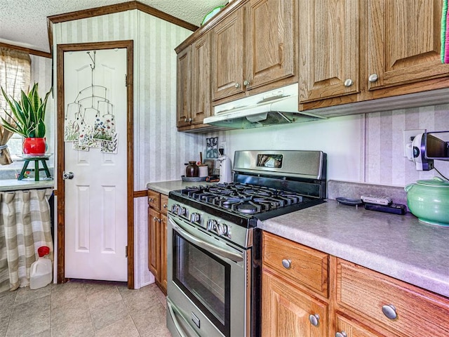 19519 N 2730th Rd, Kingfisher, OK 73750 - kitchen featuring gas range, wallpapered walls, under cabinet range hood, ornamental molding, and a textured ceiling