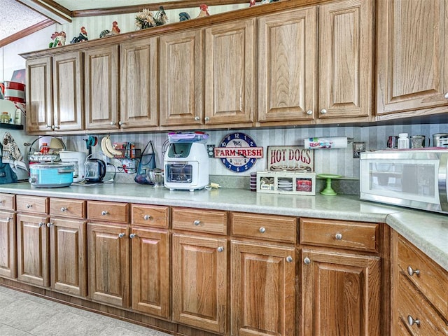 19519 N 2730th Rd, Kingfisher, OK 73750 - kitchen featuring white microwave, brown cabinetry, light countertops, and tasteful backsplash