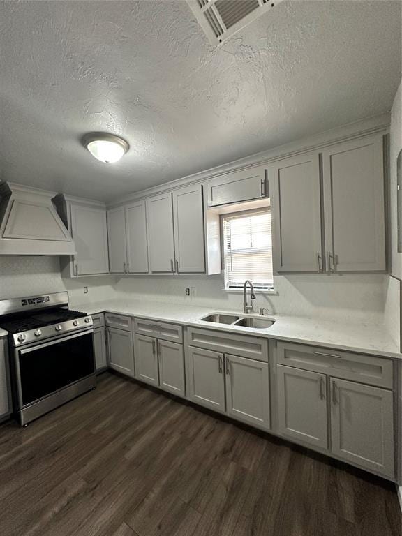 327 SW Grand Blvd, Oklahoma City, OK 73109 - kitchen with stainless steel range with gas cooktop, custom exhaust hood, dark wood-type flooring, a textured ceiling, and gray cabinetry