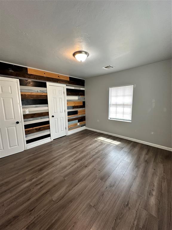 327 SW Grand Blvd, Oklahoma City, OK 73109 - unfurnished bedroom with dark wood-type flooring and baseboards