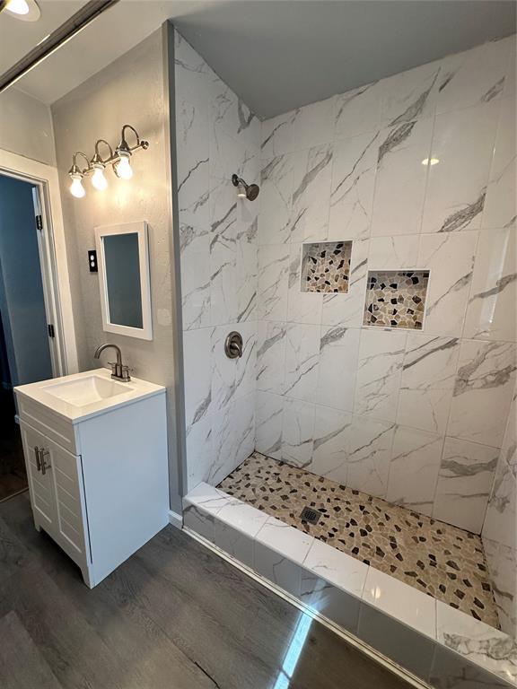327 SW Grand Blvd, Oklahoma City, OK 73109 - full bathroom featuring vanity, tiled shower, and wood finished floors