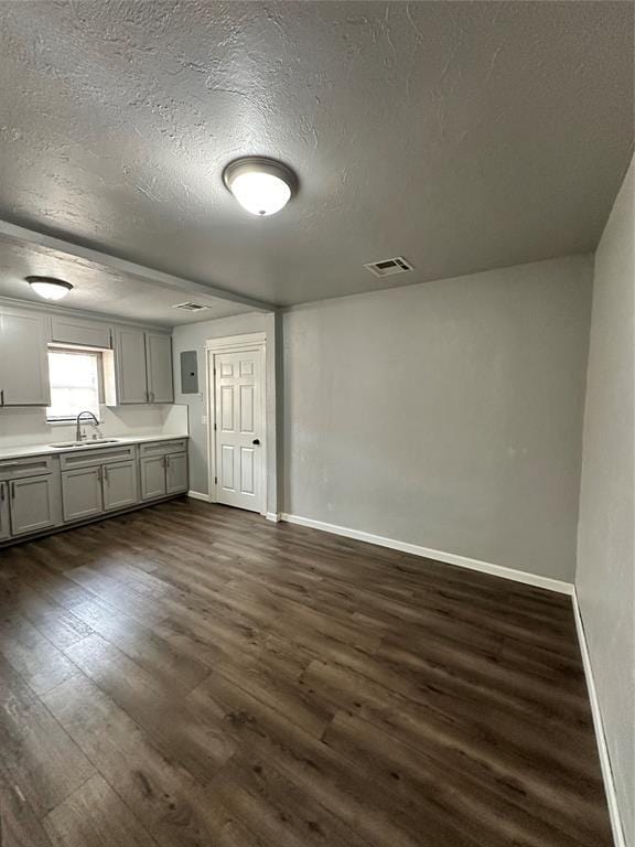 327 SW Grand Blvd, Oklahoma City, OK 73109 - kitchen with gray cabinets, a textured ceiling, dark wood-style floors, electric panel, and light countertops