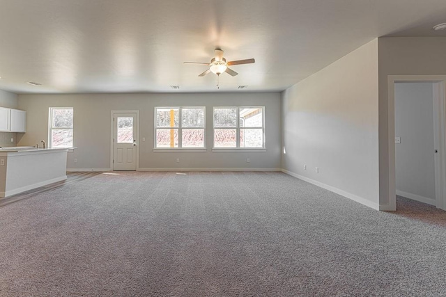 741 Stella Trl, Guthrie, OK 73044 - unfurnished living room with ceiling fan, healthy amount of natural light, baseboards, and light carpet