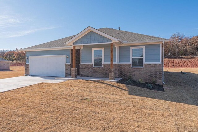 741 Stella Trl, Guthrie, OK 73044 - view of front of house with driveway, an attached garage, brick siding, and a front lawn