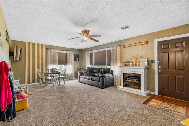 26114 State Highway 19, Cyril, OK 73029 - carpeted living area featuring a ceiling fan, a textured ceiling, a glass covered fireplace, and baseboards