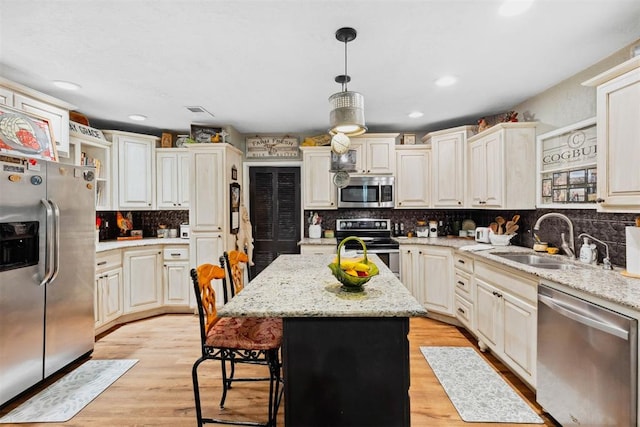 26114 State Highway 19, Cyril, OK 73029 - kitchen featuring stainless steel appliances, a sink, a kitchen island, decorative backsplash, and pendant lighting