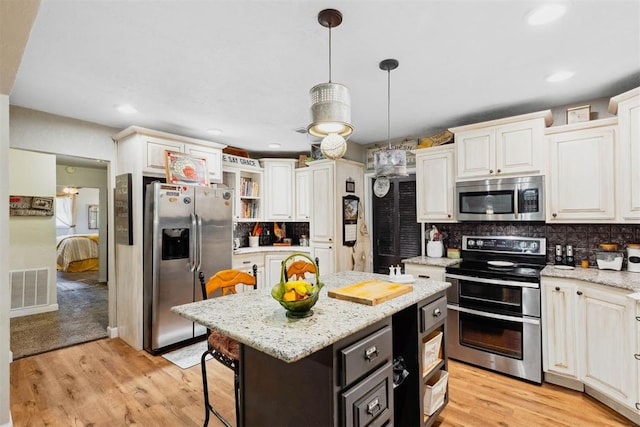 26114 State Highway 19, Cyril, OK 73029 - kitchen featuring appliances with stainless steel finishes, backsplash, a kitchen island, light wood-style flooring, and recessed lighting