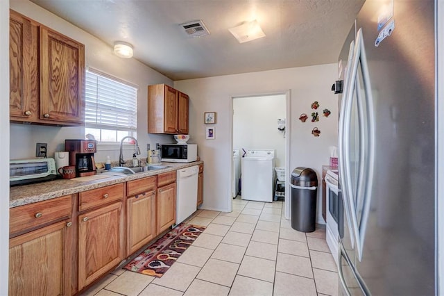 122 Cotton Tail Dr, Shawnee, OK 74804 - kitchen with stainless steel appliances, light tile patterned floors, brown cabinetry, and light countertops