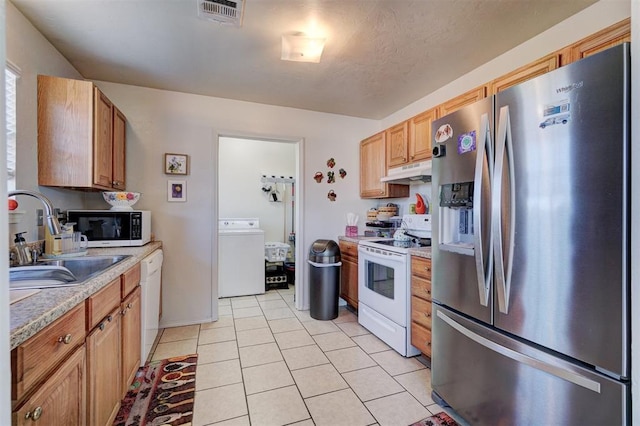122 Cotton Tail Dr, Shawnee, OK 74804 - kitchen featuring white appliances, washer / clothes dryer, under cabinet range hood, light tile patterned floors, and light countertops
