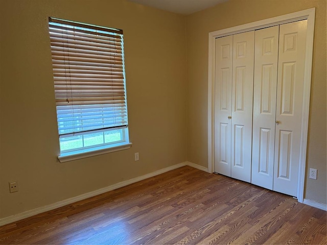 1617 Briarcreek, Norman, OK 73071 - unfurnished bedroom with wood finished floors, a closet, and baseboards
