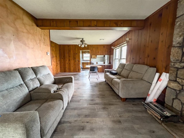 8701 Cornforth Rd, Guthrie, OK 73044 - living room with wood finished floors, wood walls, a textured ceiling, ceiling fan, and beamed ceiling