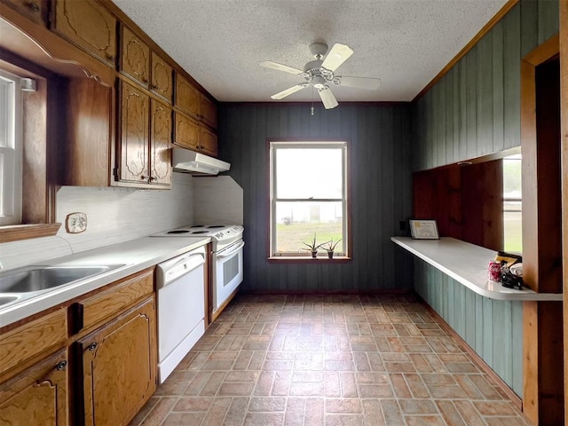 8701 Cornforth Rd, Guthrie, OK 73044 - kitchen featuring dishwasher, under cabinet range hood, brick patterned flooring, light countertops, and wood walls