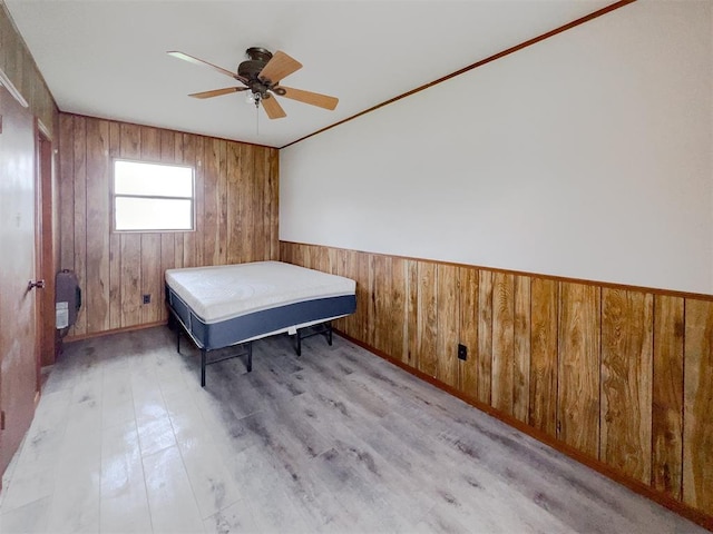 8701 Cornforth Rd, Guthrie, OK 73044 - bedroom with light wood-style flooring, wood walls, and a ceiling fan