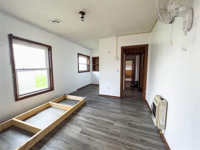 8701 Cornforth Rd, Guthrie, OK 73044 - empty room featuring heating unit, wood finished floors, baseboards, and a textured ceiling